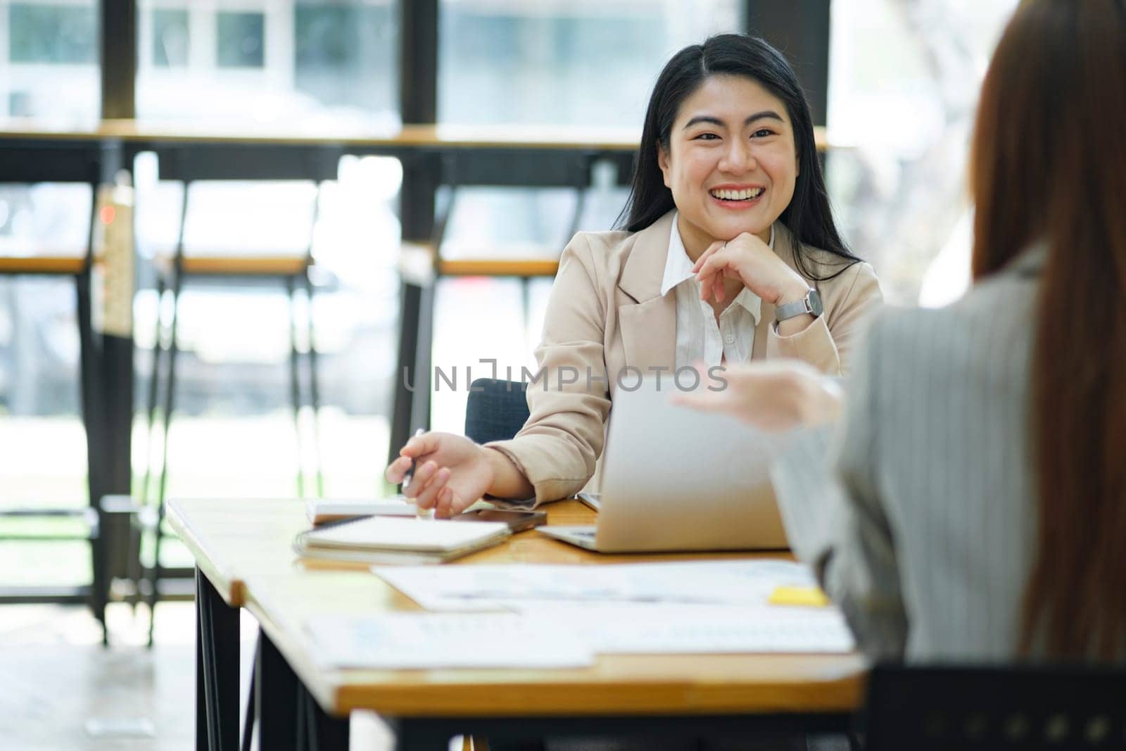 Two business professionals engaged in a serious discussion, possibly conducting a job interview in a modern office environment.
