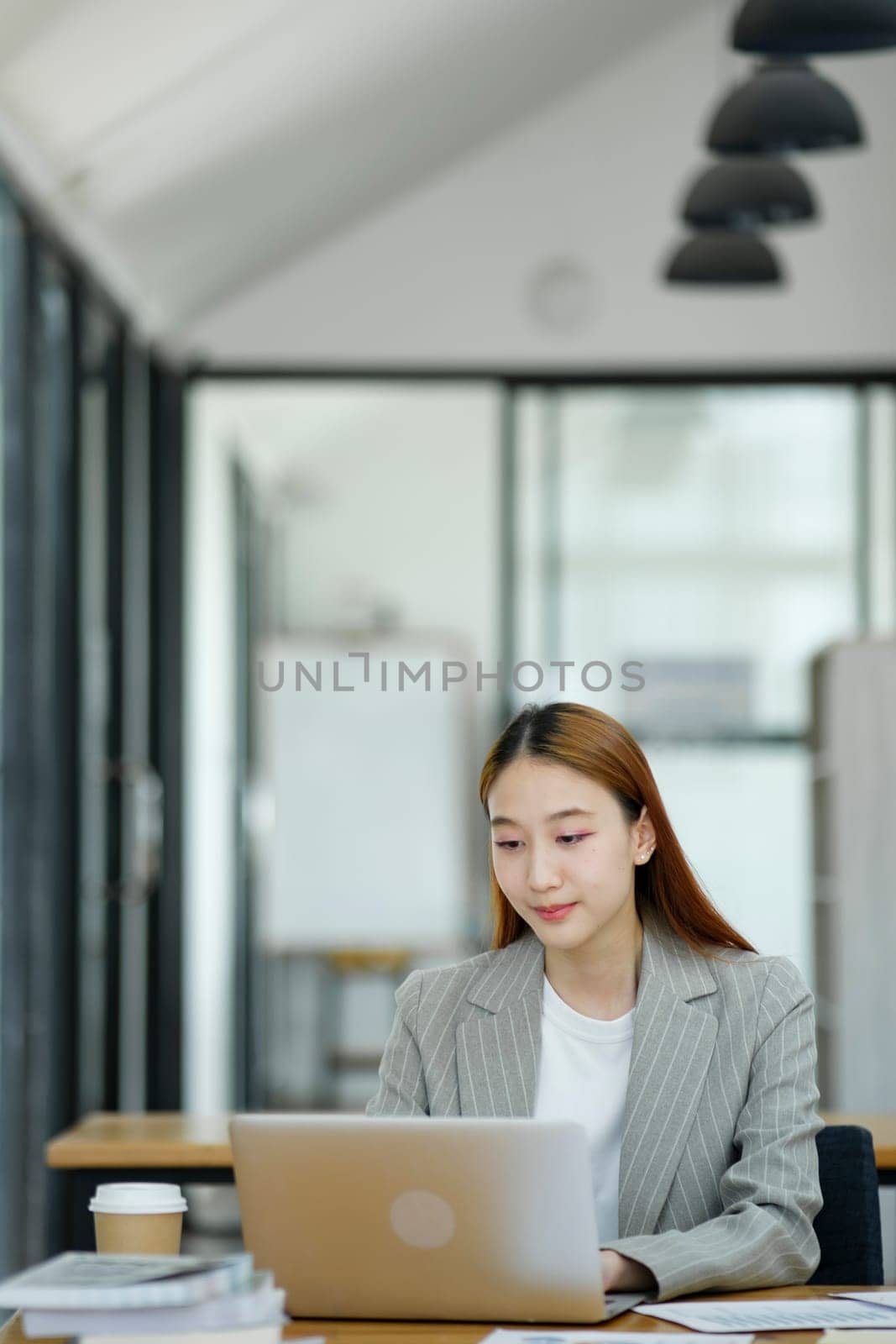 Woman sitting at work on a casual day with coffee.