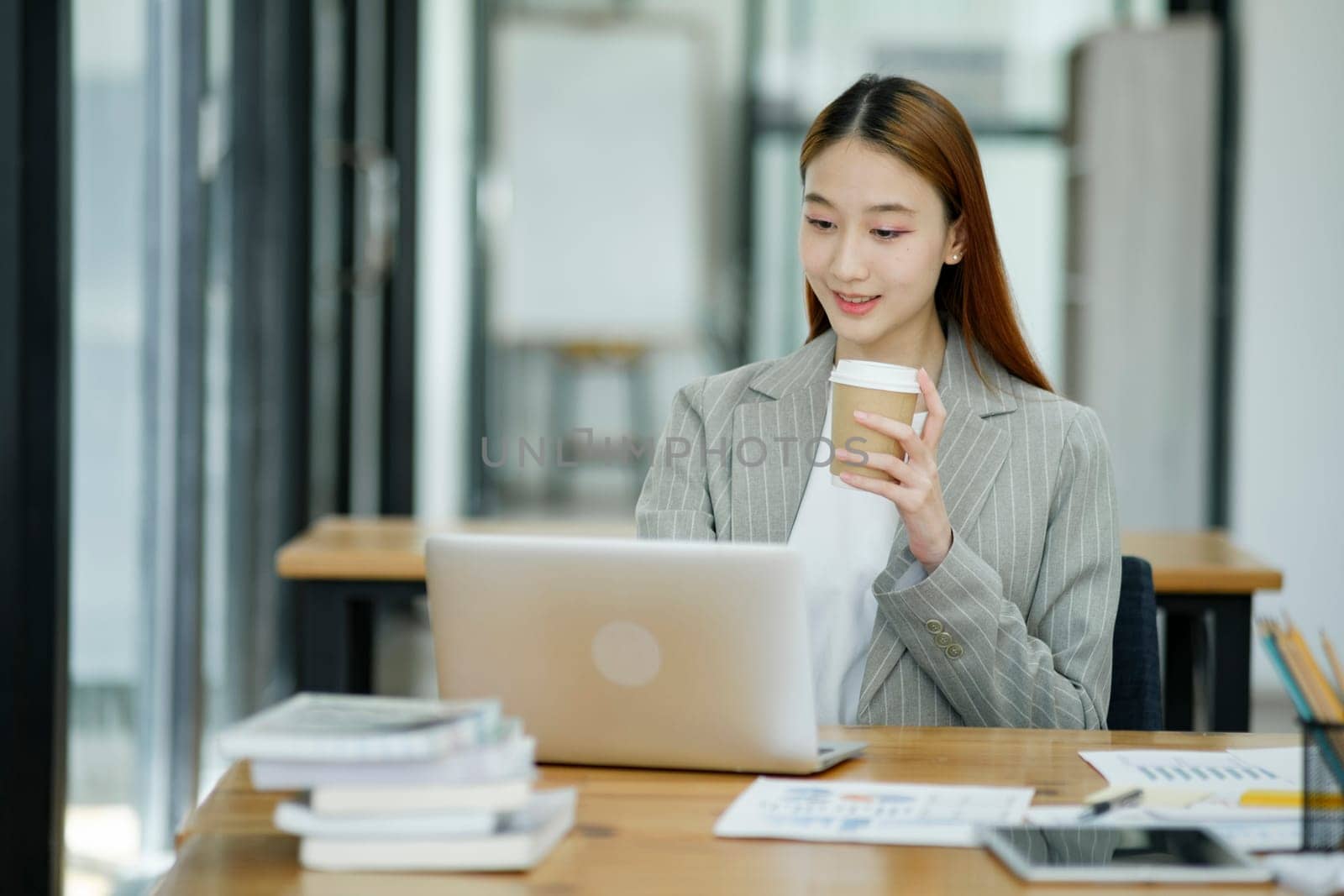 Woman sitting at work on a casual day with coffee.