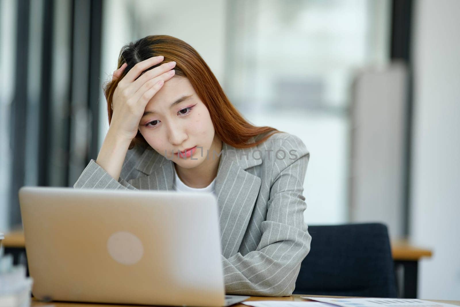 Female employees are stressed and tired. Headache from thinking and pressure from work.