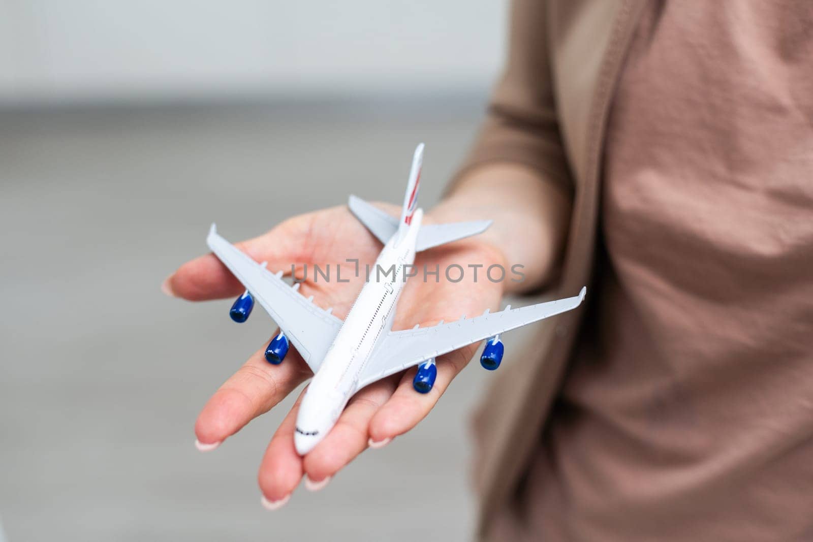 woman's hand holding toy airplane, isolated on white background. High quality photo