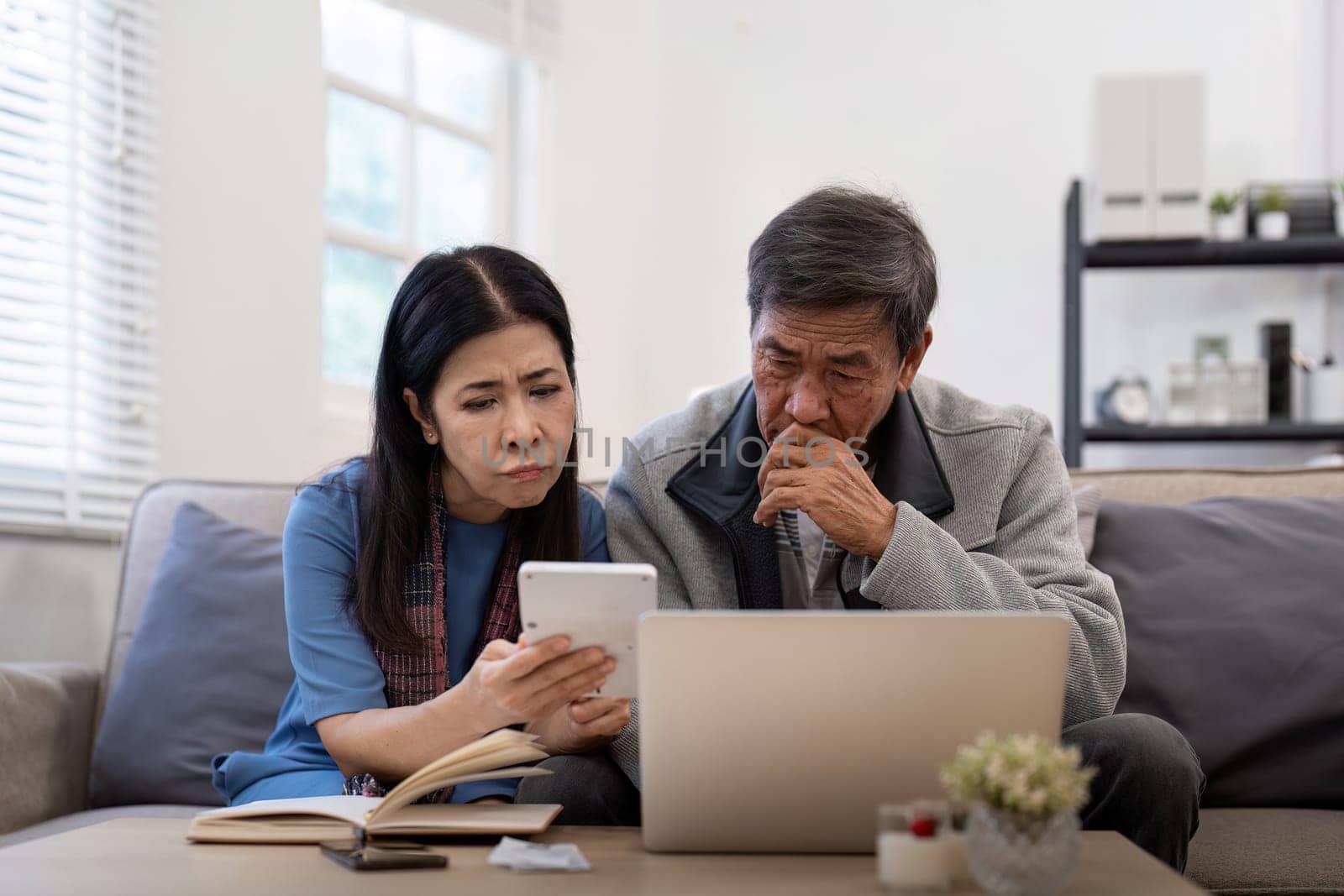 Serious stressed asian senior old couple worried about bill discuss unpaid bank debt paper payment worry about money problem.