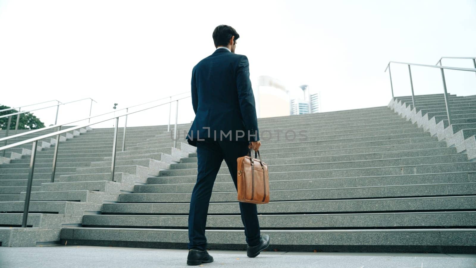 Closeup image of business man walking up stairs in low angle camera. Exultant. by biancoblue