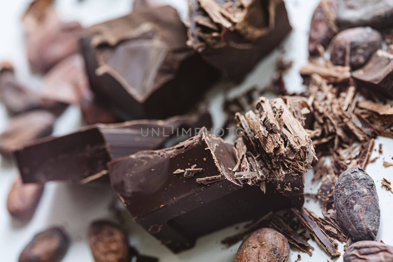 Cocoa beans with chocolate on a white background. Shalllow dof. Top view