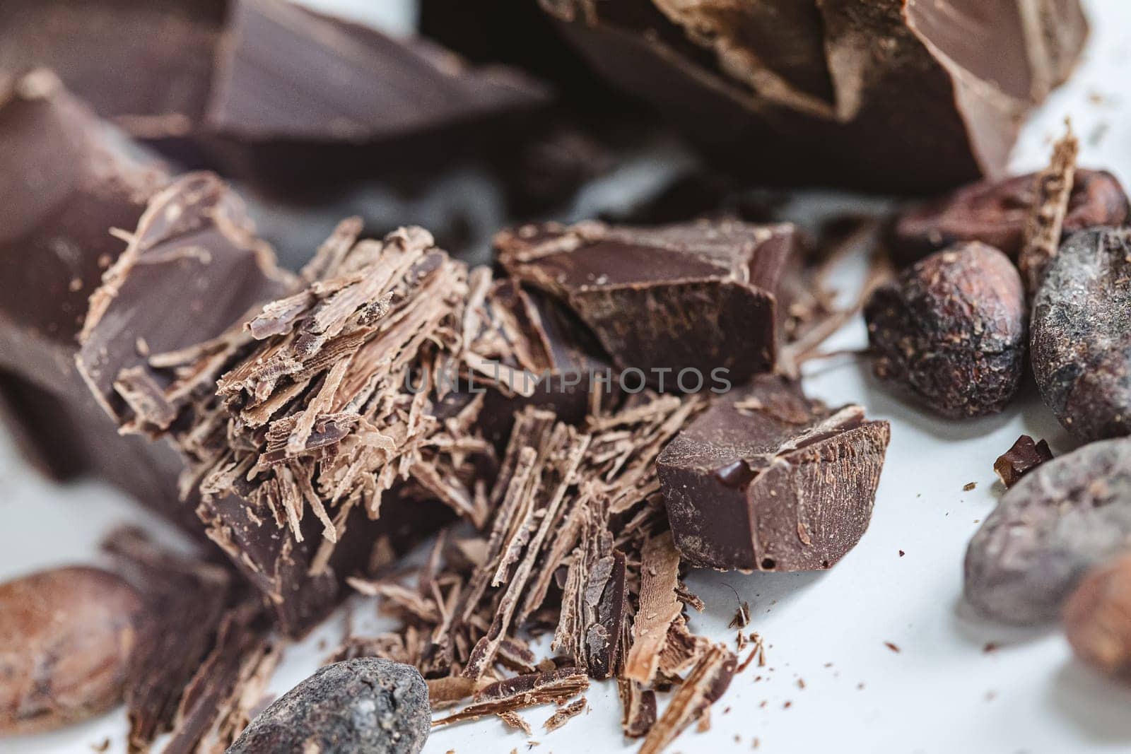 Cocoa beans with chocolate on a white background. Shalllow dof. Top view