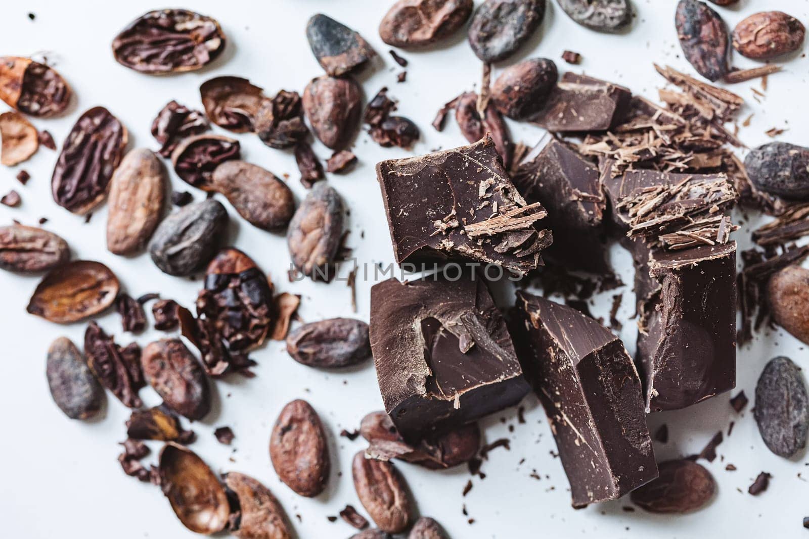 Cocoa beans with chocolate on a white background. Shalllow dof. Top view