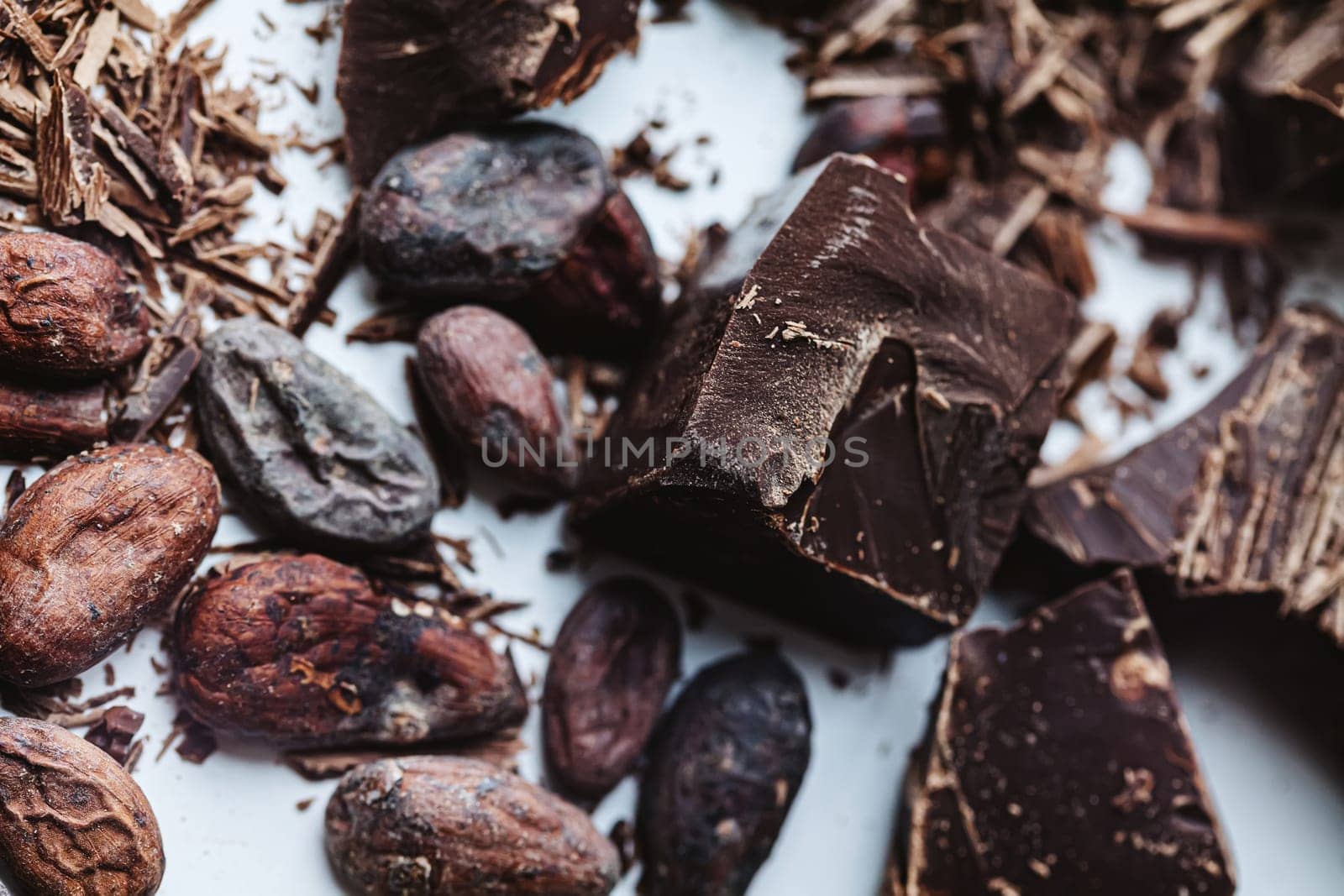 Cocoa beans with chocolate on a white background. Shalllow dof. Top view