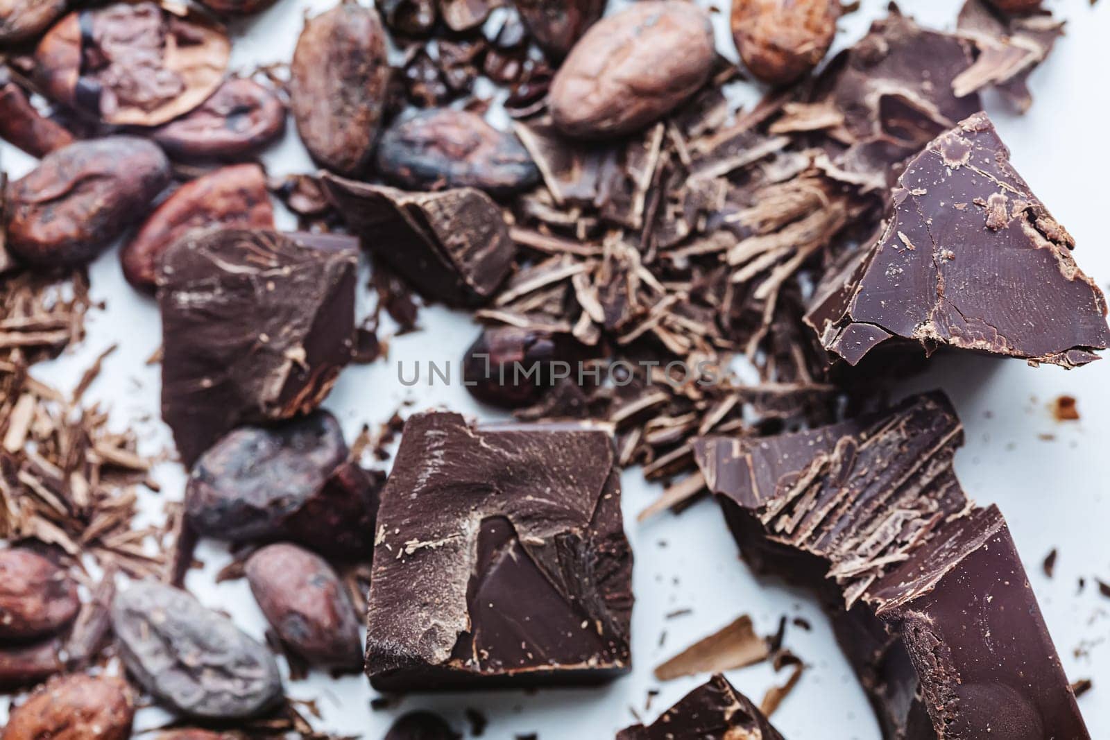 Cocoa beans with chocolate on a white background. Shalllow dof. Top view