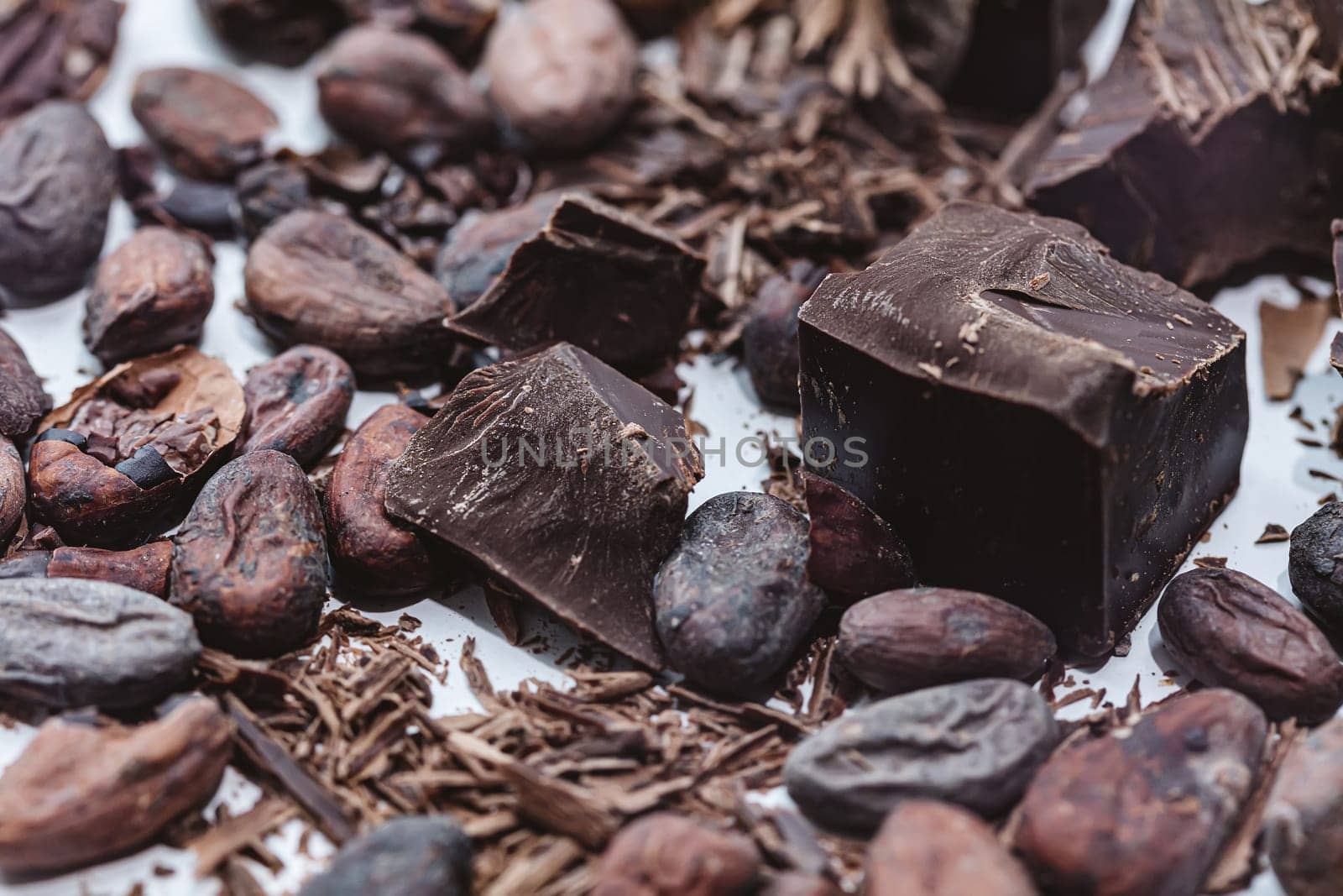 Cocoa beans with chocolate on a white background. Shalllow dof. Top view