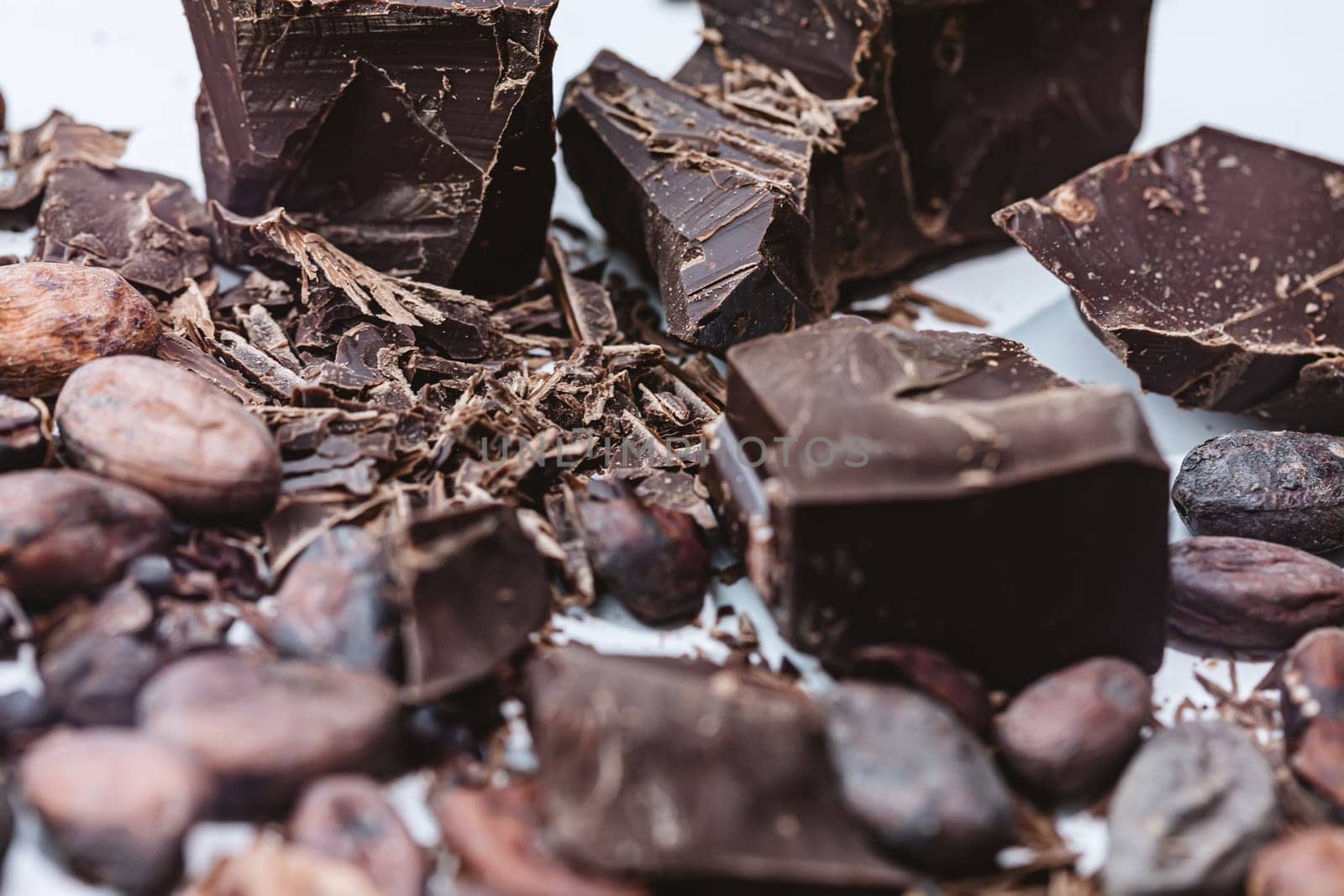 Cocoa beans with chocolate on a white background. Shalllow dof. Top view