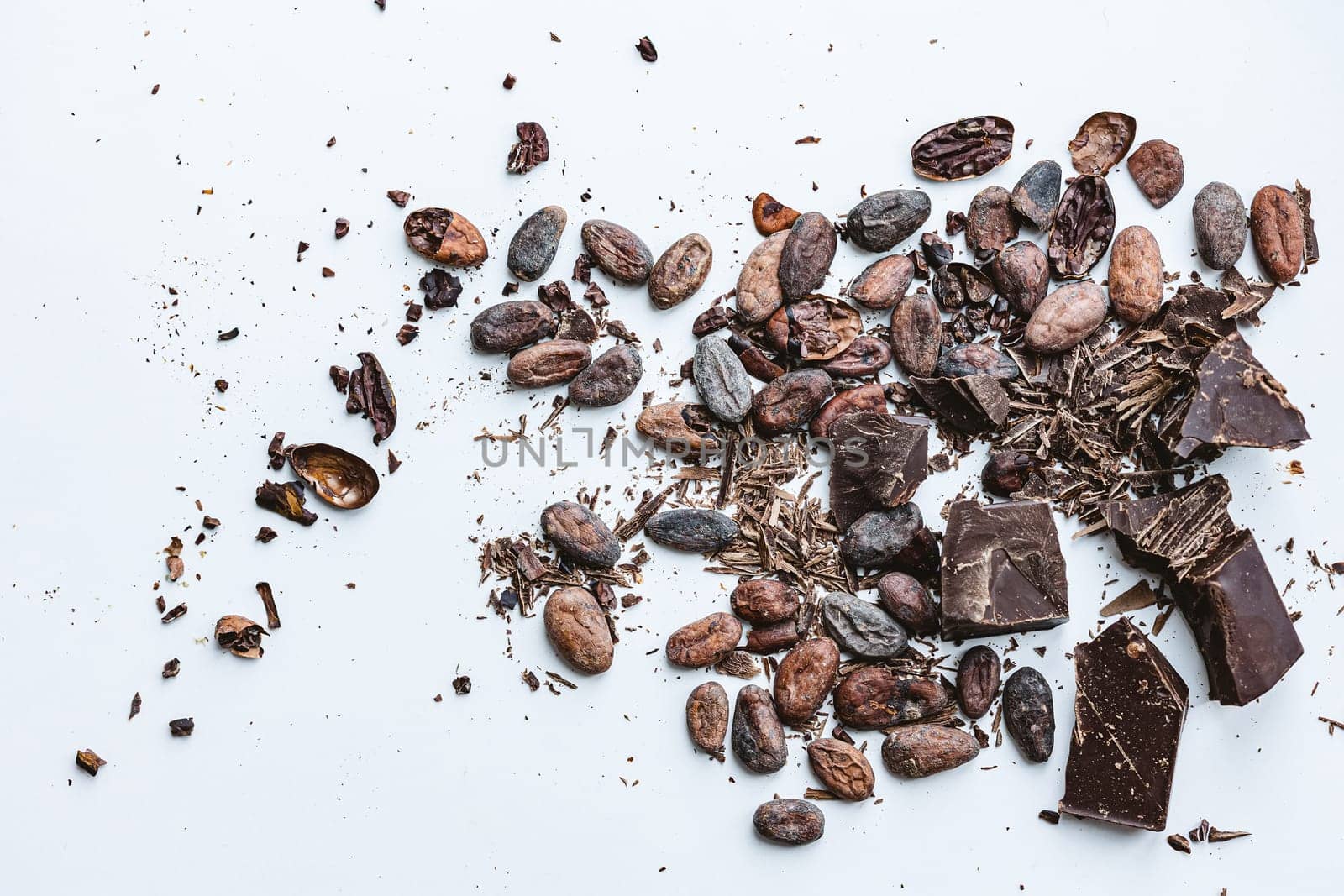 Cocoa beans and broken chocolate on white background. Top view copy space. Shallow dof by sarymsakov