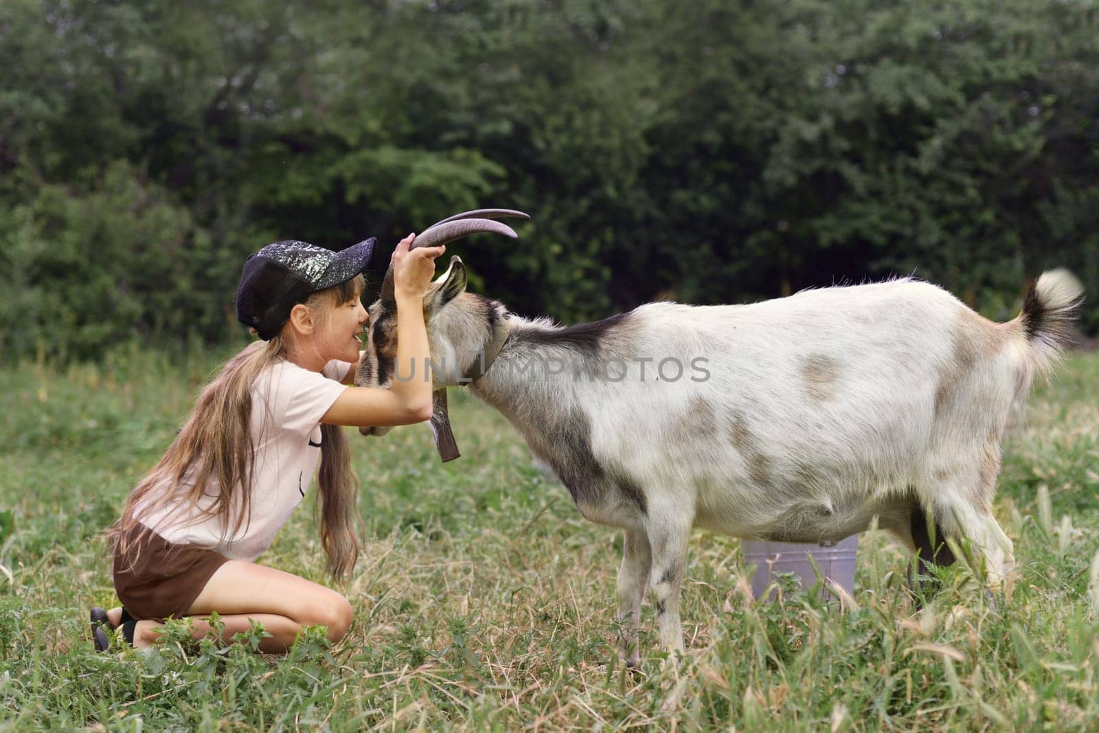 Girl hugging her goat as a friend in the village