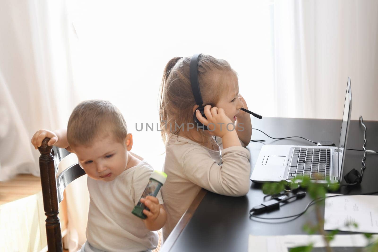 Little children play with computer of parents by Godi