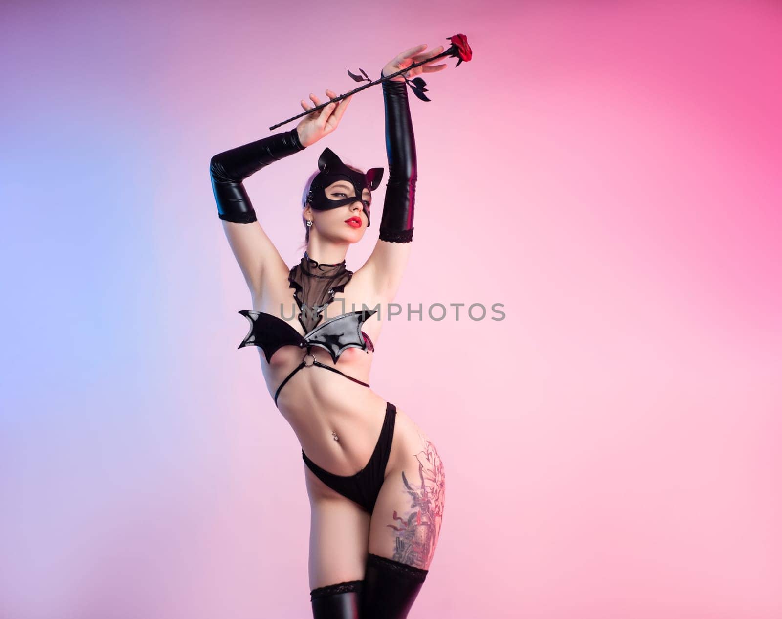 Sexy girl in lingerie, leather cat mask for BDSM costume for sex games on a pink bright background copy paste