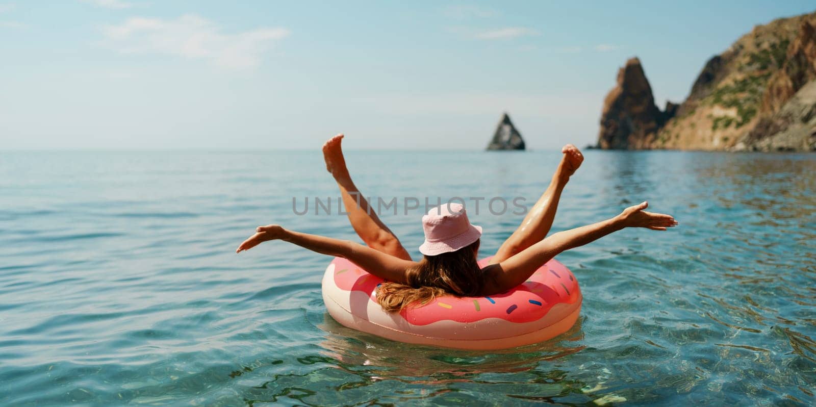 Summer vacation woman in hat floats on an inflatable donut mattress. Happy woman relaxing and enjoying family summer travel holidays travel on the sea. by Matiunina