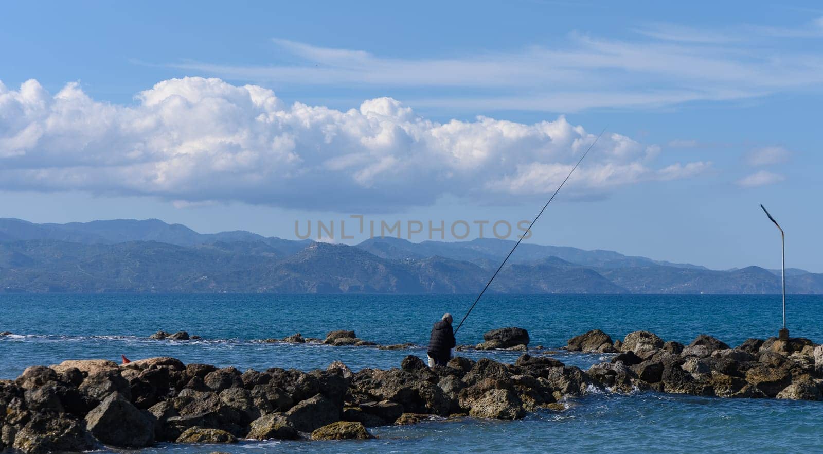 Gaziveren/Cyprus-05.02.2024: fisherman catches fish in the mediterranean sea