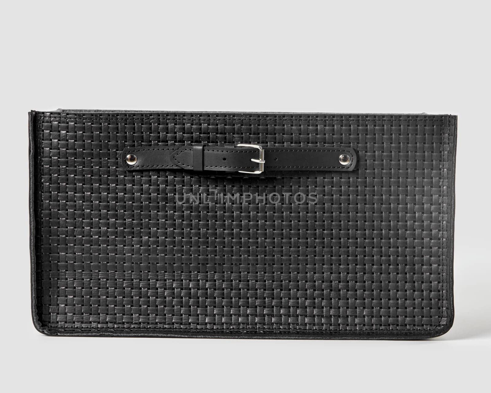 Front view of functional black woven leather storage box with sturdy build and convenient applied handles for stylish organization of space. Modern artisanal accessory for interior design