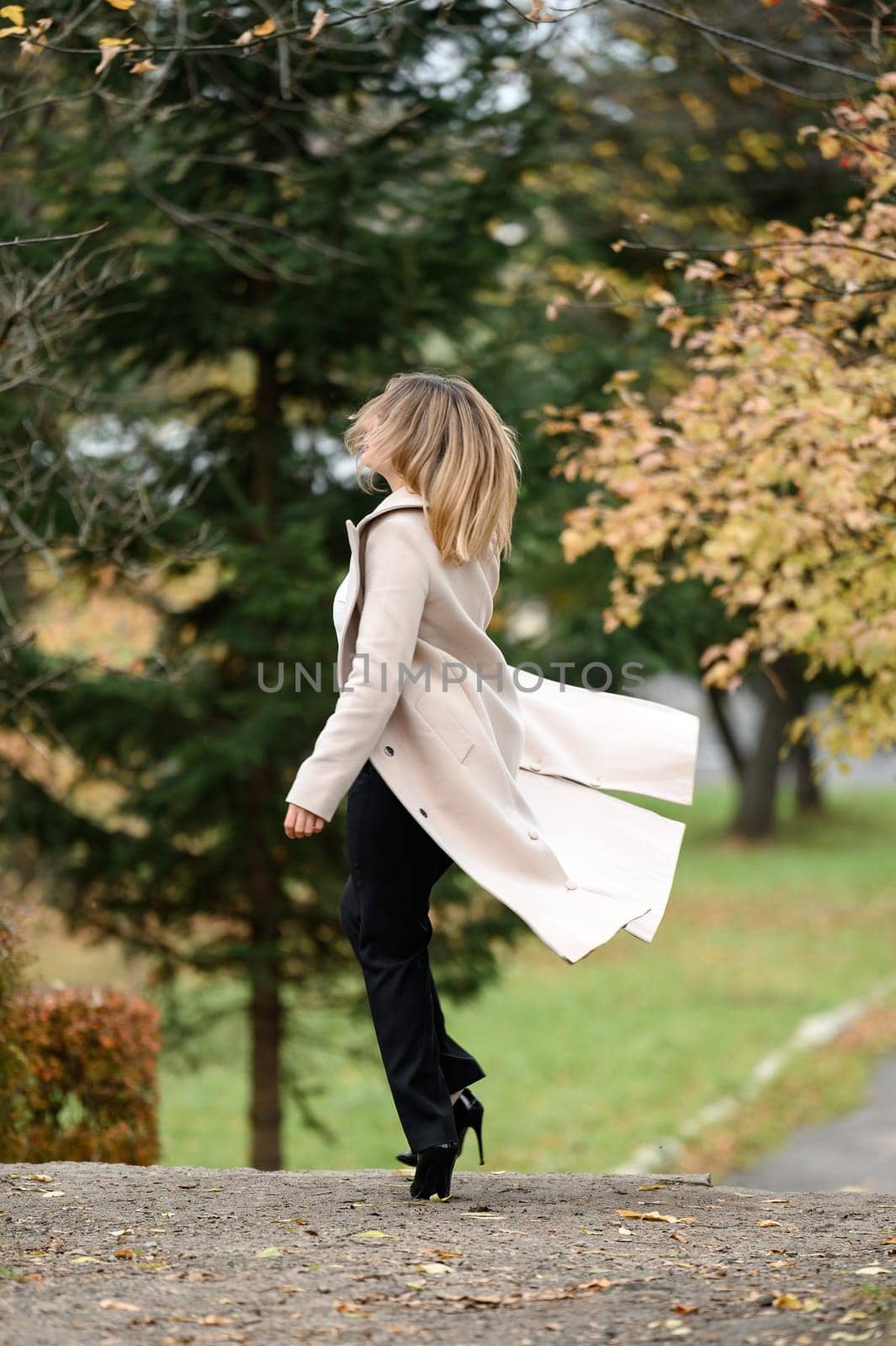 A young girl in an autumn park on a photo shoot, a theme for an autumn calendar, a happy girl in a park.