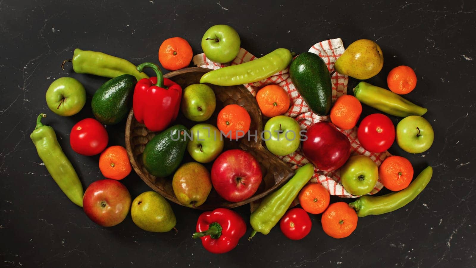 Mixed fruits and vegetables on black marble like board, healthy food concept, view from above
