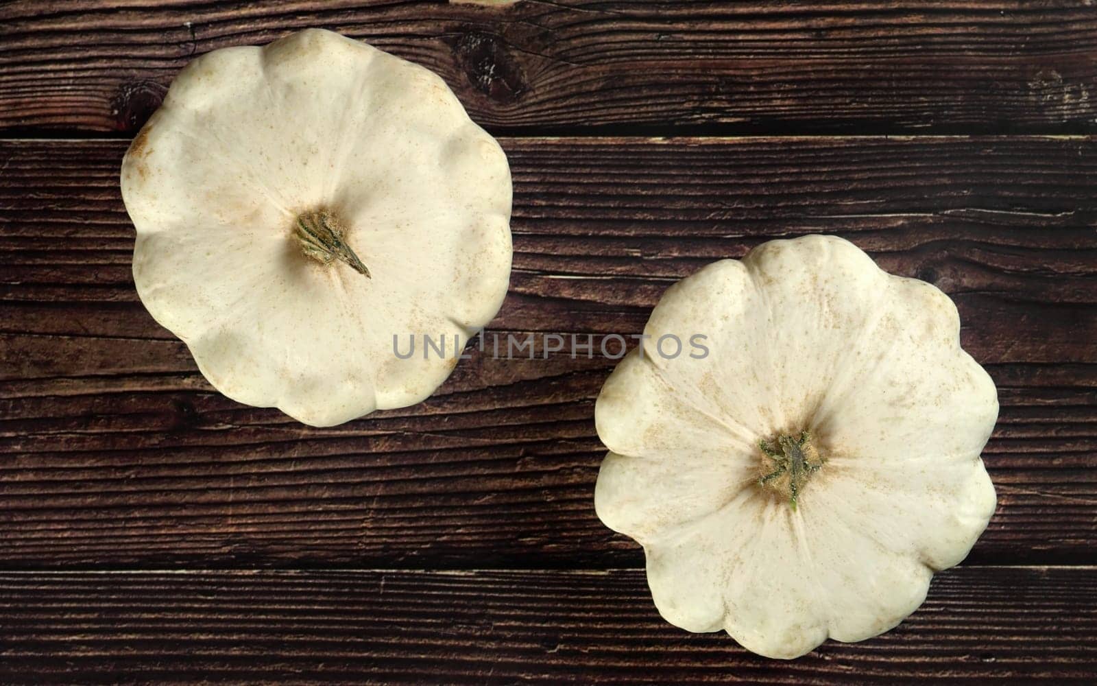 White pattypan squash heads on dark wooden board, view from above
