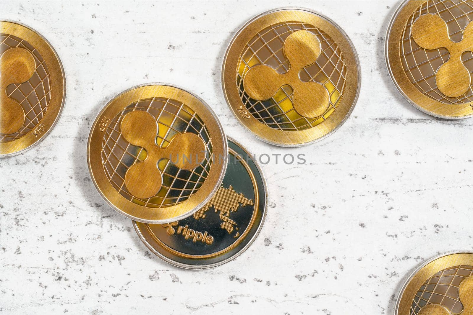Top down view - XRP ripple cryptocurrency  golden coins on white stone like board
