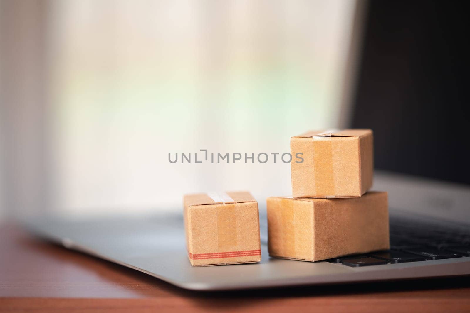 Stack of cardboard boxes on a laptop keyboard by iamnoonmai