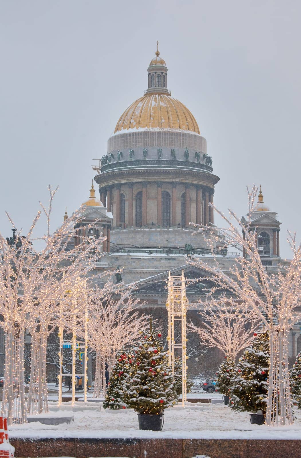Russia, St Petersburg, 30 December 2023: people walk among Christmas trees in heavy snowfall, a park organized on holidays near St. Isaac's Cathedral and the monument to Emperor Nicholas II. High quality 4k footage