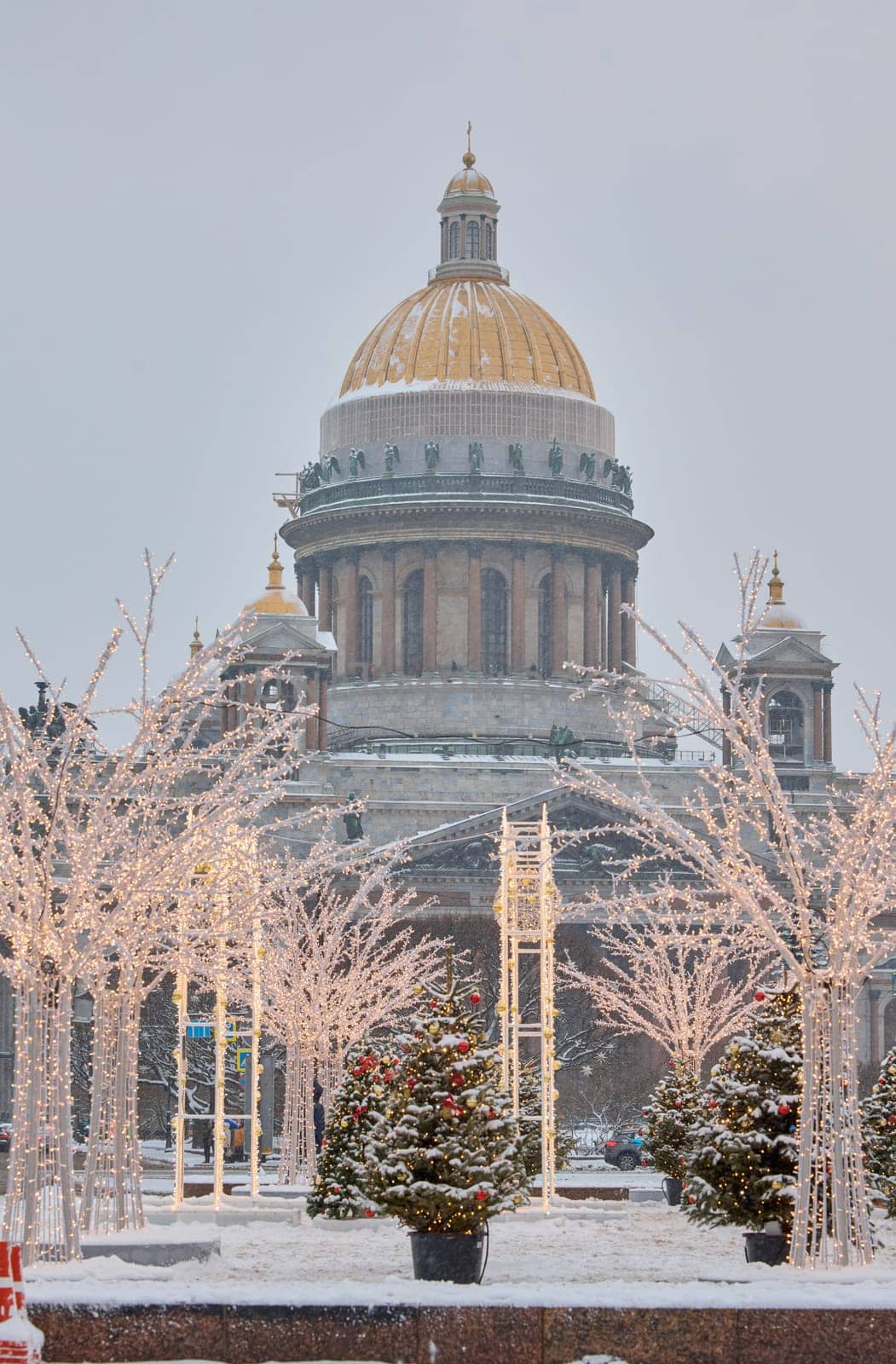 Russia, St Petersburg, 30 December 2023: people walk among Christmas trees in heavy snowfall, a park organized on holidays near St. Isaac's Cathedral and the monument to Emperor Nicholas II by vladimirdrozdin