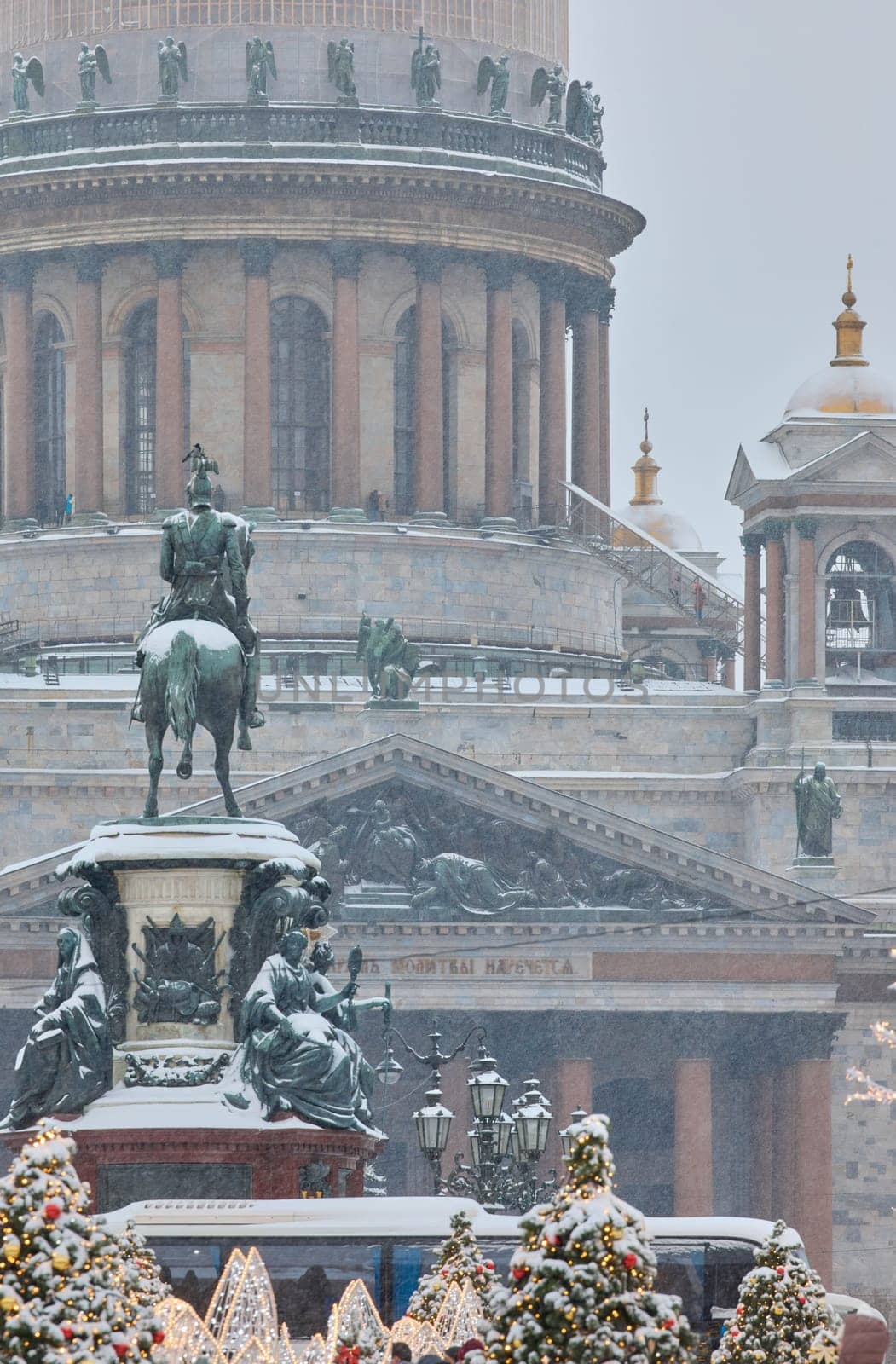 Russia, St Petersburg, 30 December 2023: people walk among Christmas trees in heavy snowfall, a park organized on holidays near St. Isaac's Cathedral and the monument to Emperor Nicholas II. High quality 4k footage