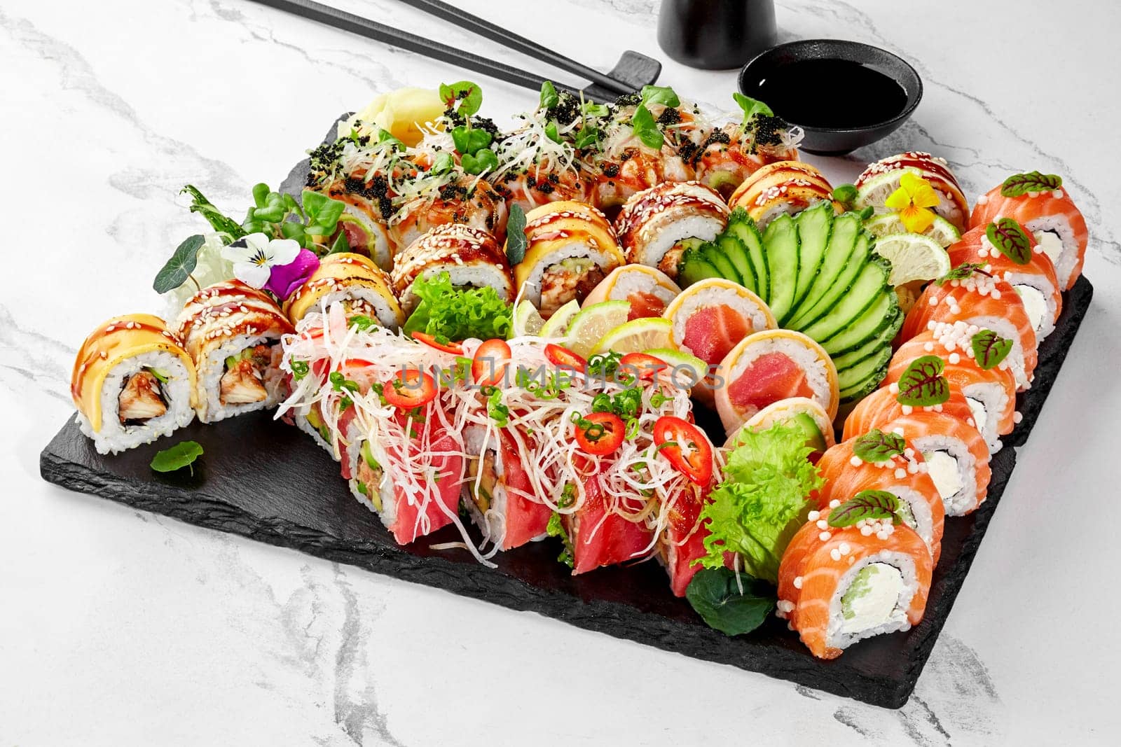 Assorted sushi platter with elegant garnishes on slate board by nazarovsergey