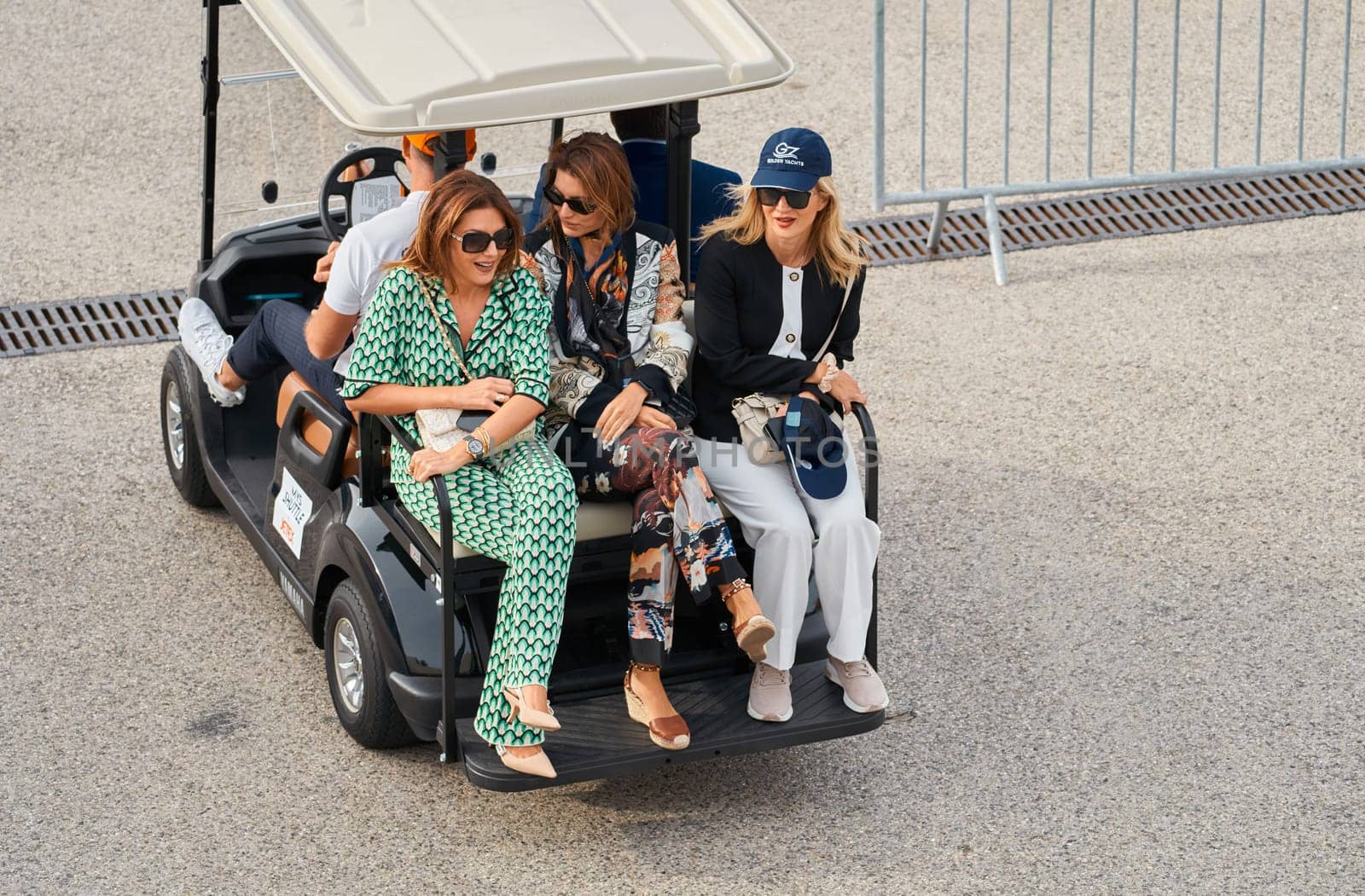 Monaco, Monte Carlo, 29 September 2022 - several beautiful women are riding in an electric car at the famous motorboat exhibition, mega yacht show, clients and yacht brokers discuss the novelties by vladimirdrozdin