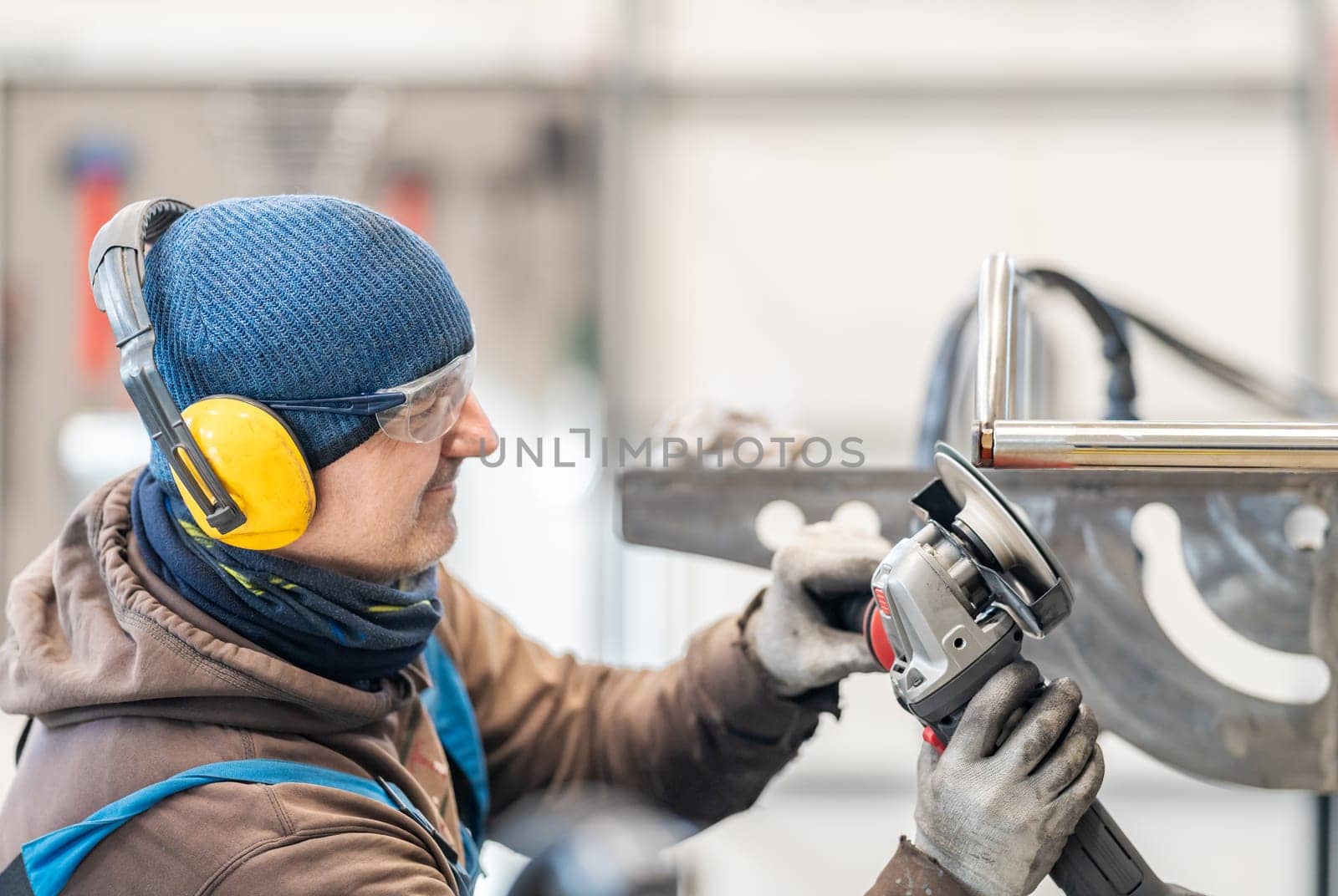 Skilled Worker Grinding Metal with Safety Equipment in Industrial Workshop.