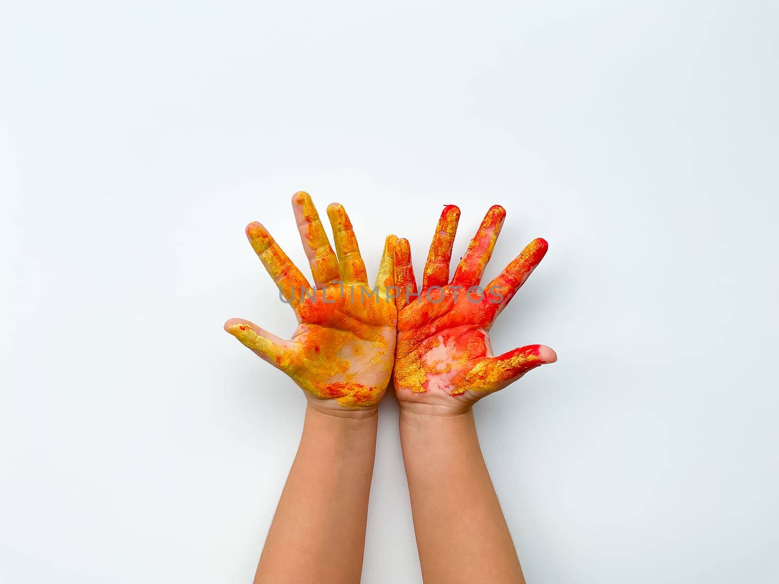 Childrens hands painted with yellow and red paint on white background. by Lunnica