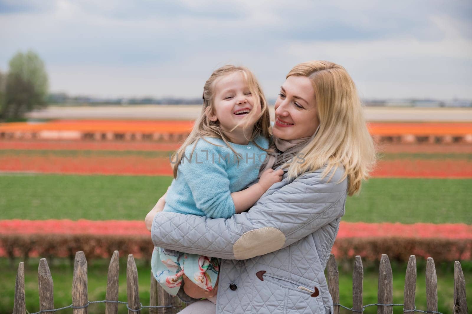 Mother and daughter laughing in Keukenhof park. Netherlands by Godi