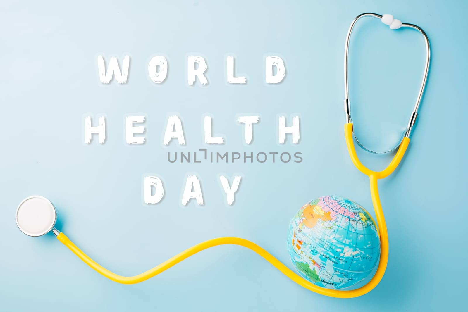 World Health Day. Yellow doctor stethoscope and world globe isolated on blue background, Save world day, Green Earth, Healthcare and medical concept