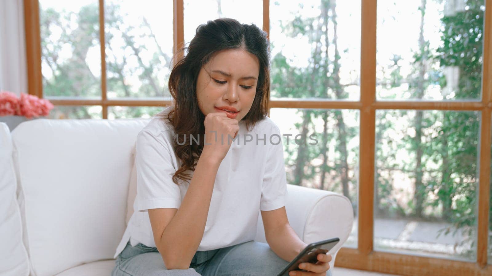 Young woman using smartphone browsing for online shopping E commerce by online payment gateway at vivancy home. Modern and convenience online purchasing make secure and convenient purchases.