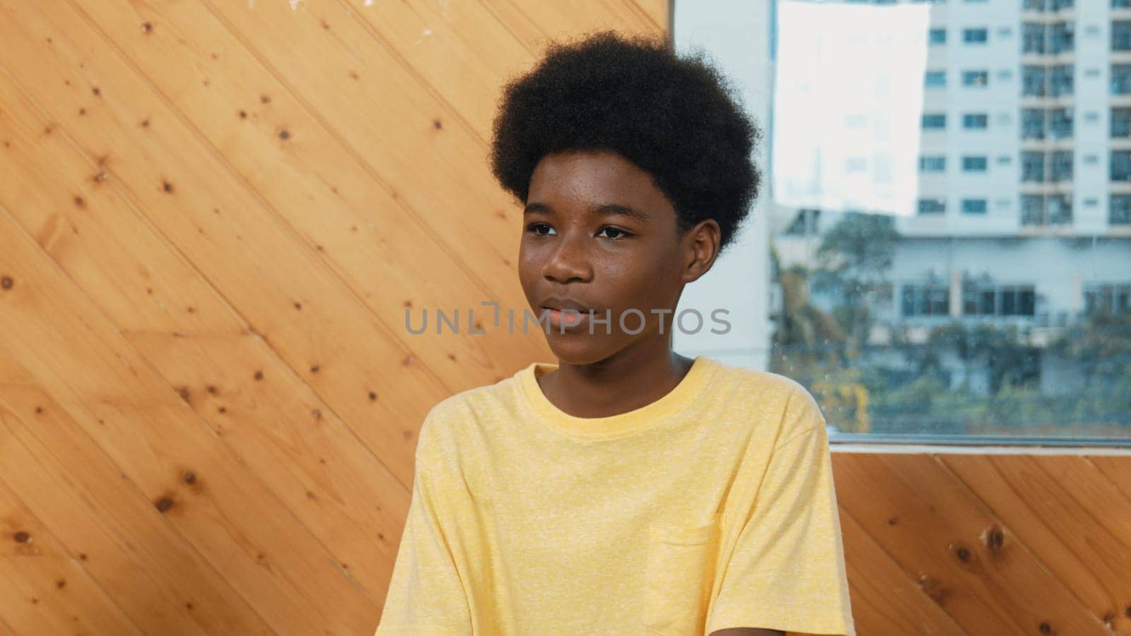 Smiling african boy sitting in circle while listening diverse friend sharing idea in group therapy with trust. Highschool student thinking and learning about mental health problem. Edification.