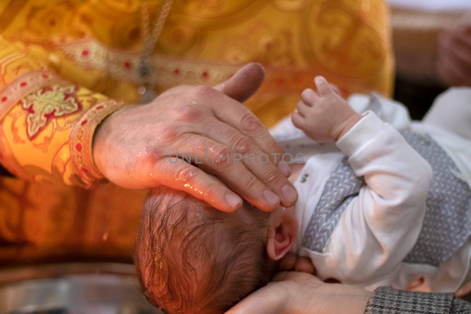 Ukraine, Khmelnitsky 02.10.2022. Infant baptism. Water is poured on the head of an infant. Christening the baby at the Orthodox church. Christian rite. orthodox rite. Christian baptism of a child