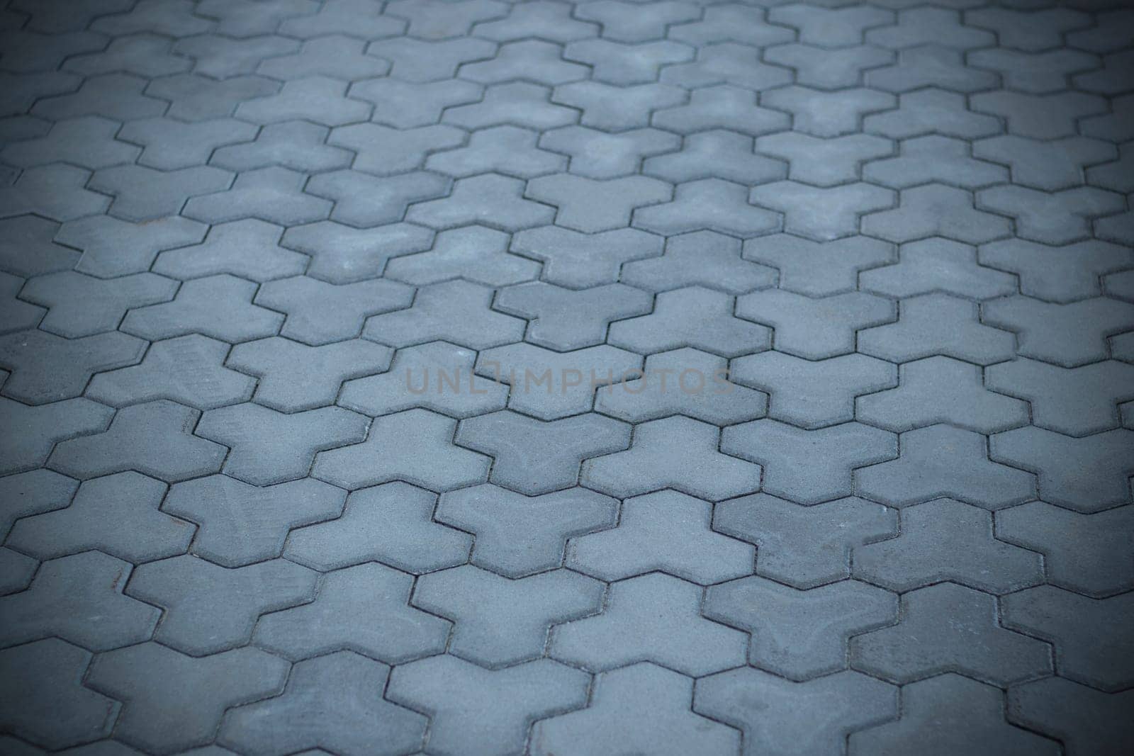 Concrete or cobble gray pavement slabs or stones for floor, wall or path. Traditional fence, court, backyard or road paving. Abstract background - gray paving slabs in the form of squares.