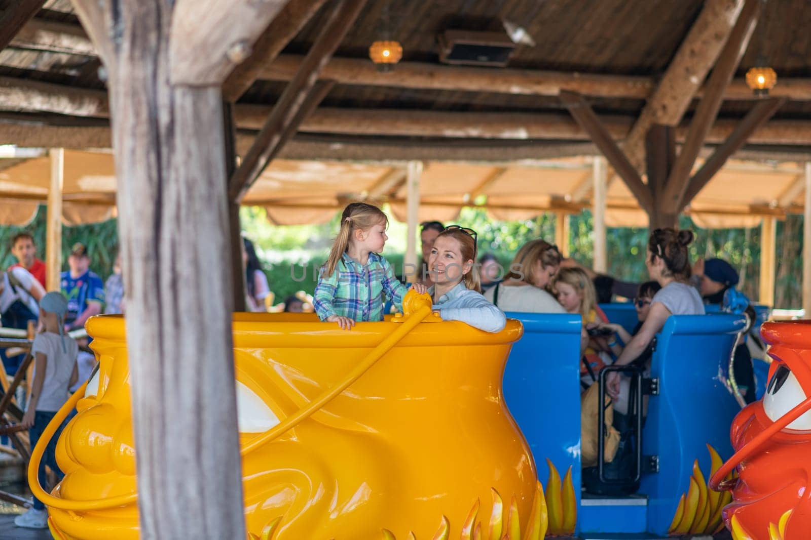 KAATSHEUVEL, NETHERLANDS - APRIL 19, 2019: Mother and daughter ride on a swing in an amusement park of Efteling