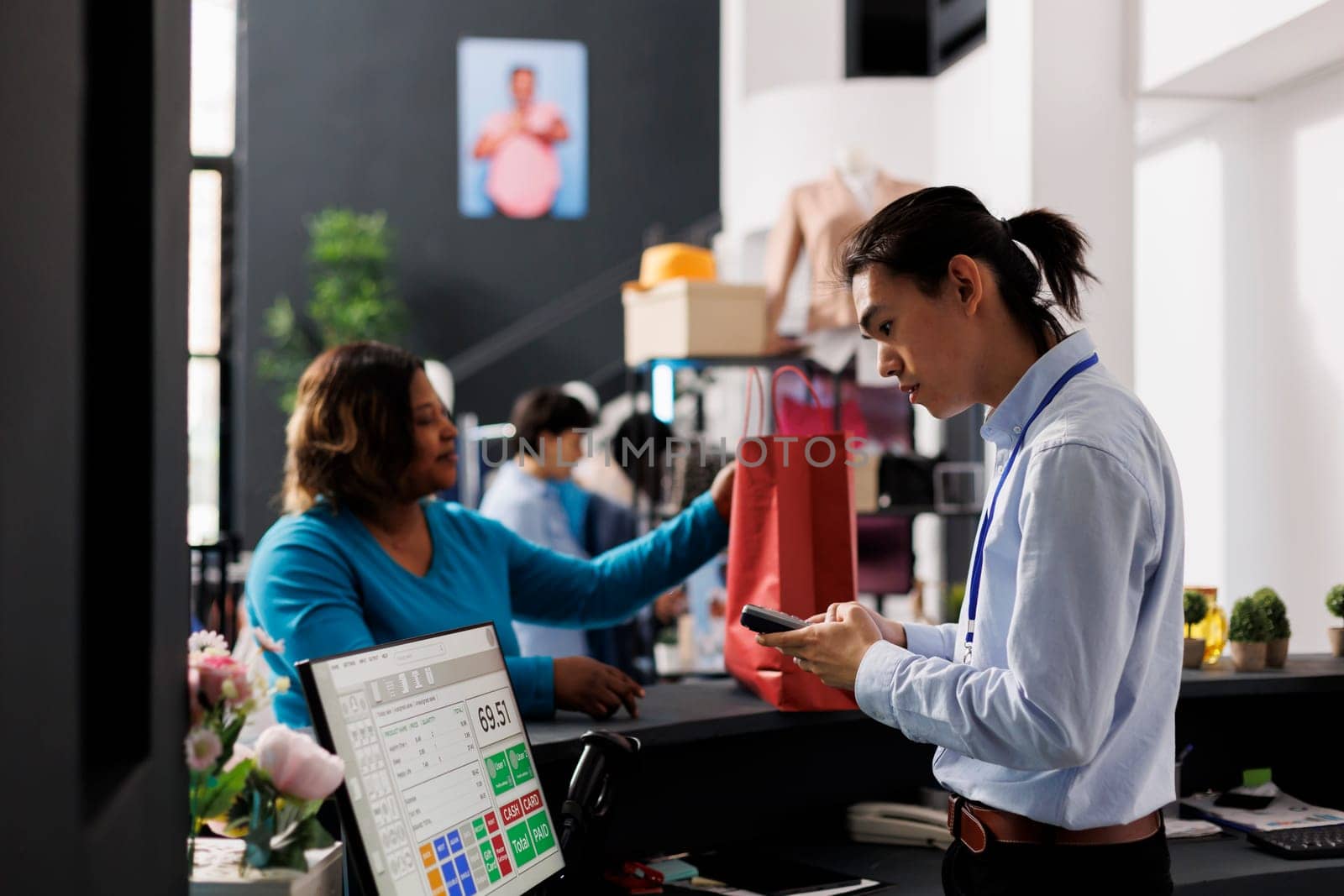 African american client paying for stylish wear, standing at counter desk in clothing store. Shopaholic african american woman shopping for fashionable clothes in modern boutique. Fashion concept