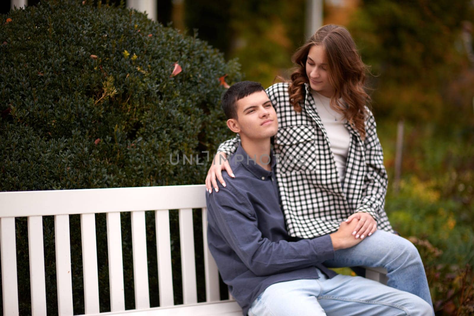 lovely young couple kissing outdoors in autumn. Loving couple walking in nature. Autumn mood. Happy man and woman hugging and kissing in autumn. Love. Fashionable couple outdoors. Fashion, people and lifestyle. Stylish couple in autumn outfit.