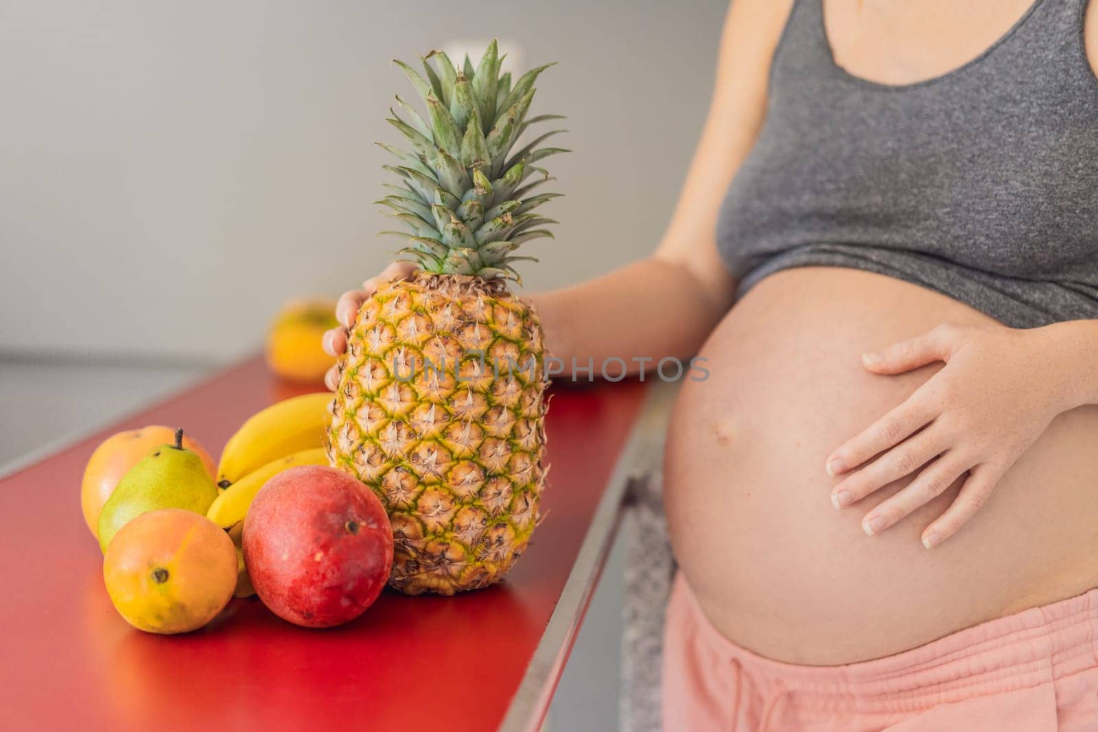 Embracing a healthy choice, a pregnant woman prepares to enjoy a nutritious moment, gearing up to eat fresh fruit and nourish herself during her pregnancy by galitskaya