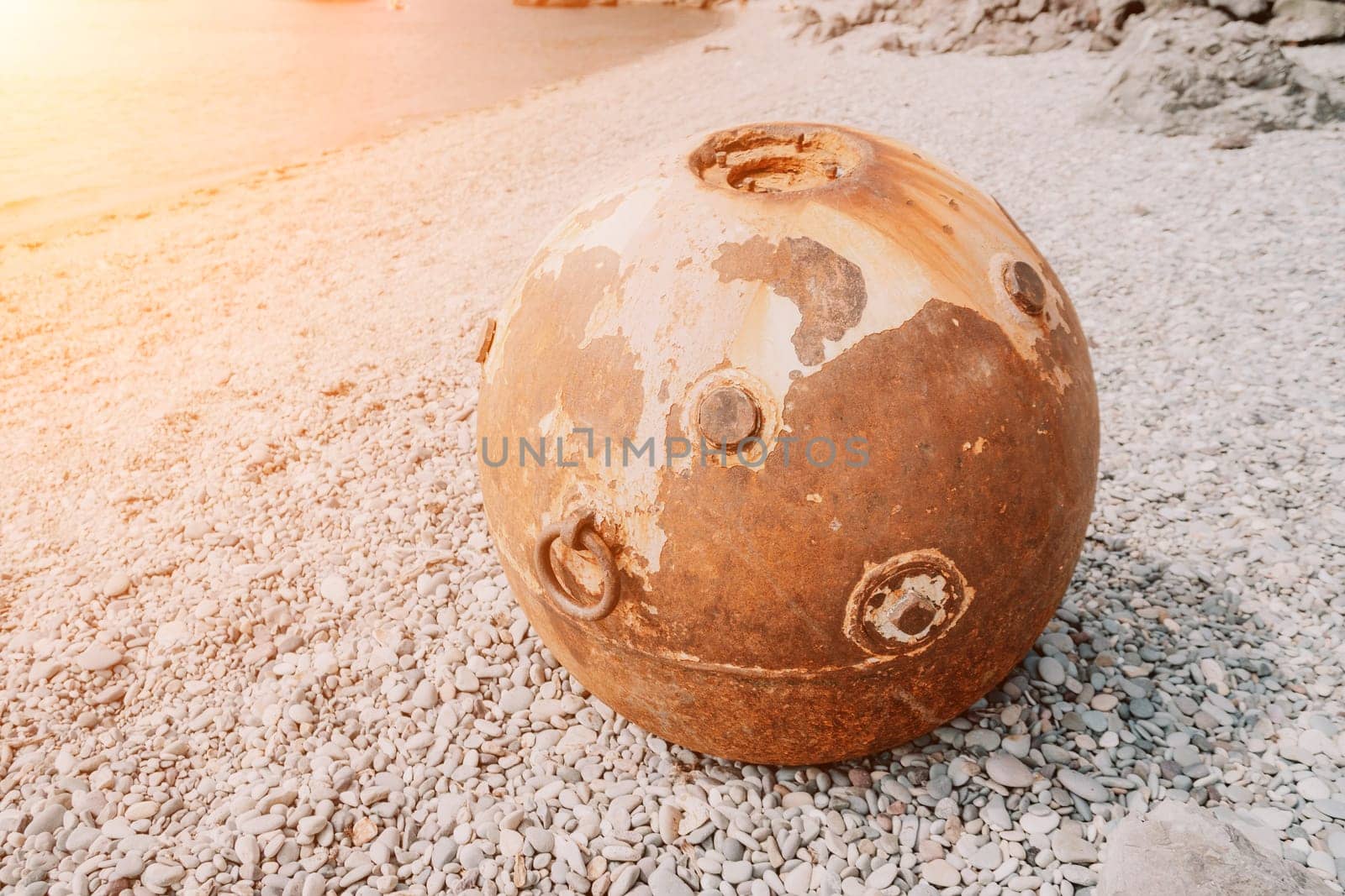 Old rusty sea mine on the beach. by panophotograph