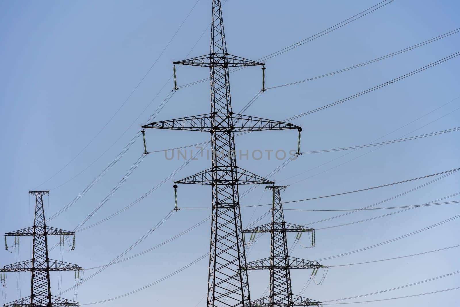 High voltage towers with sky background. Power line support with wires for electricity transmission. High voltage grid tower with wire cable at distribution station. Energy industry, energy saving by Matiunina
