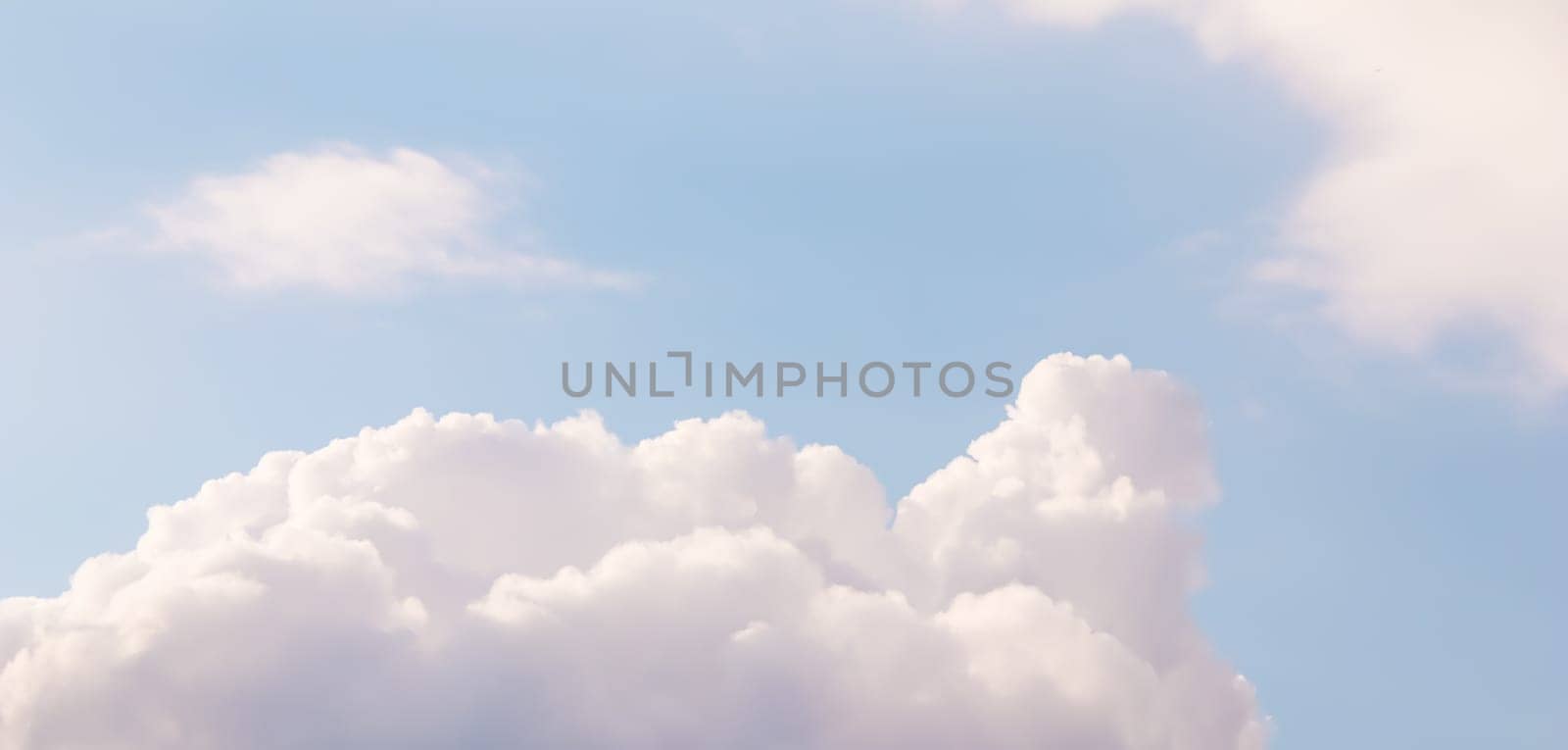 Blue sky background with pale pink clouds at sunset by Olayola