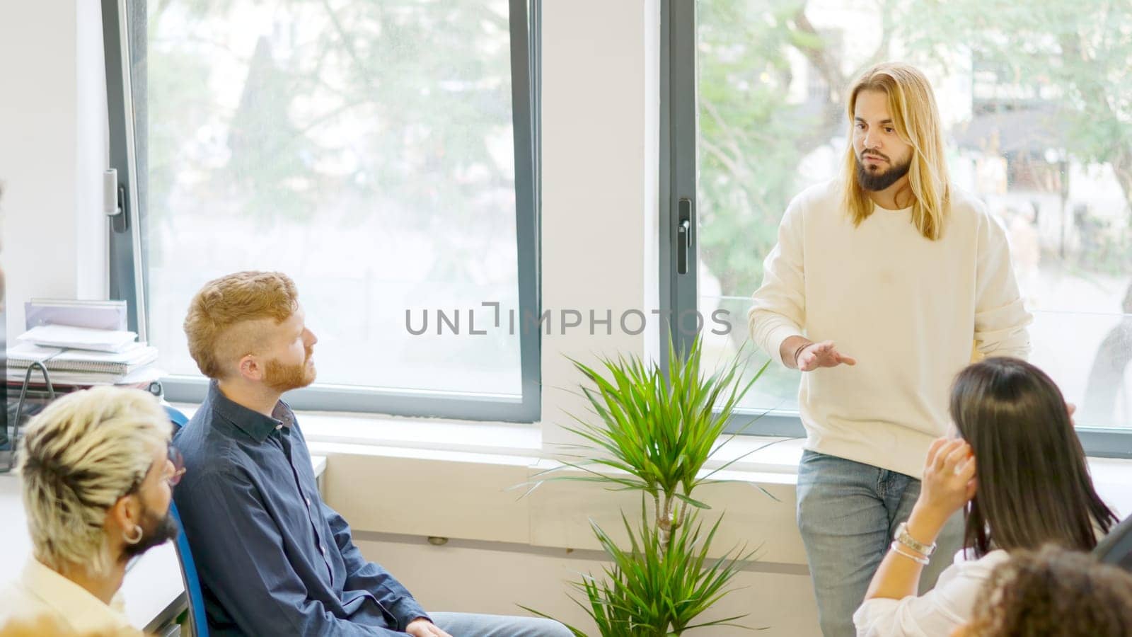 Young man talking during a business meeting in a coworking by ivanmoreno