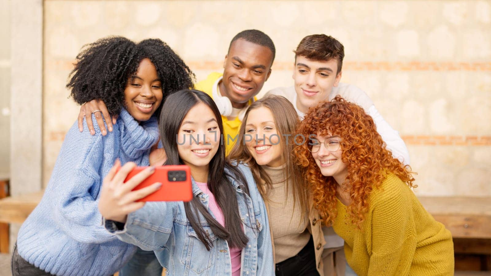 Chinese girl taking a selfie with diverse friends by ivanmoreno