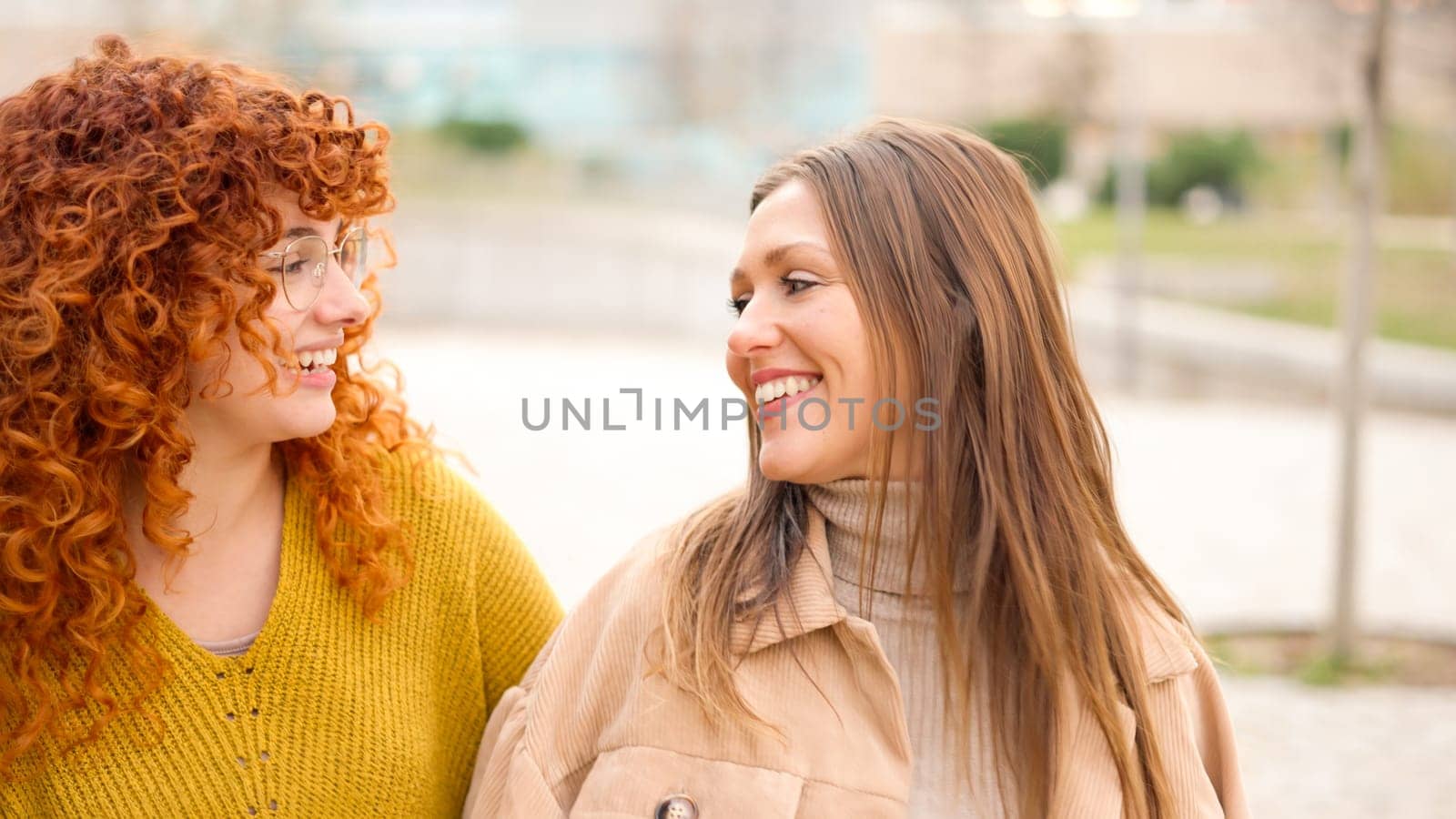 close up of female friends talking happily along the street