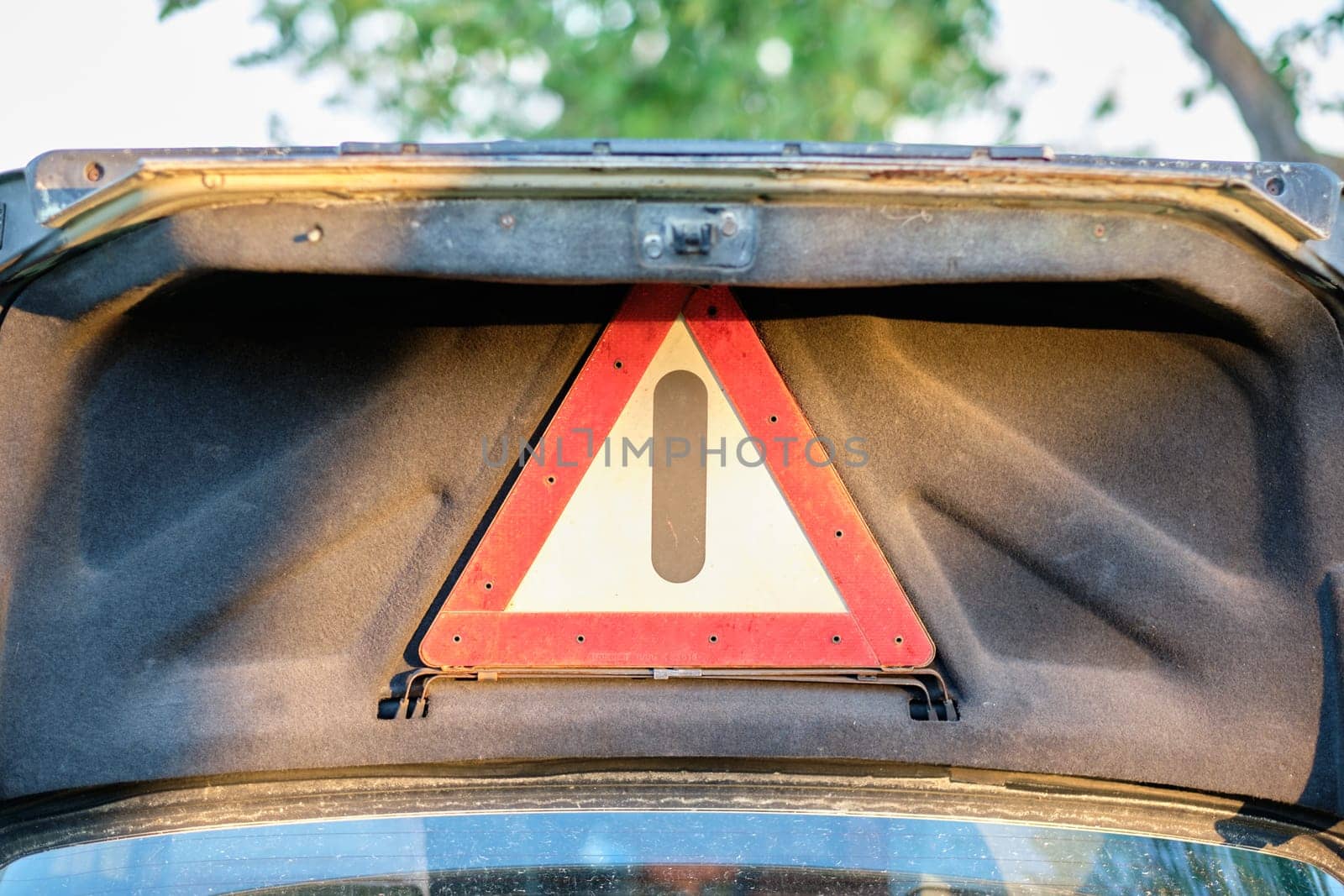 The danger warning sign on the lid of an old car. The concept of replacing a car with a safe one